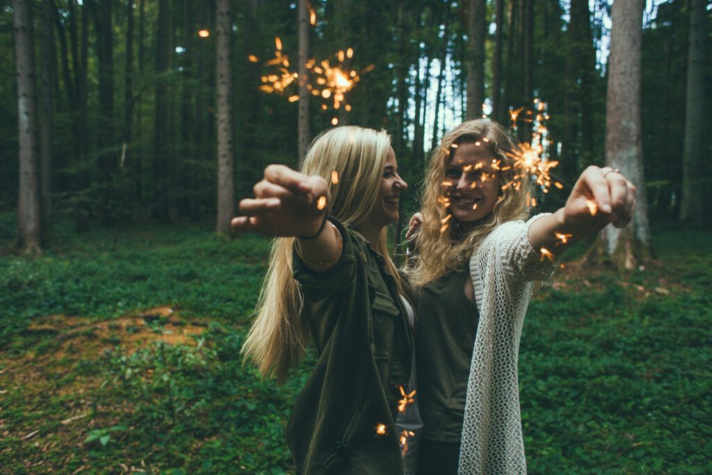 zwei junge Frauen im Wald mit winderkerzen